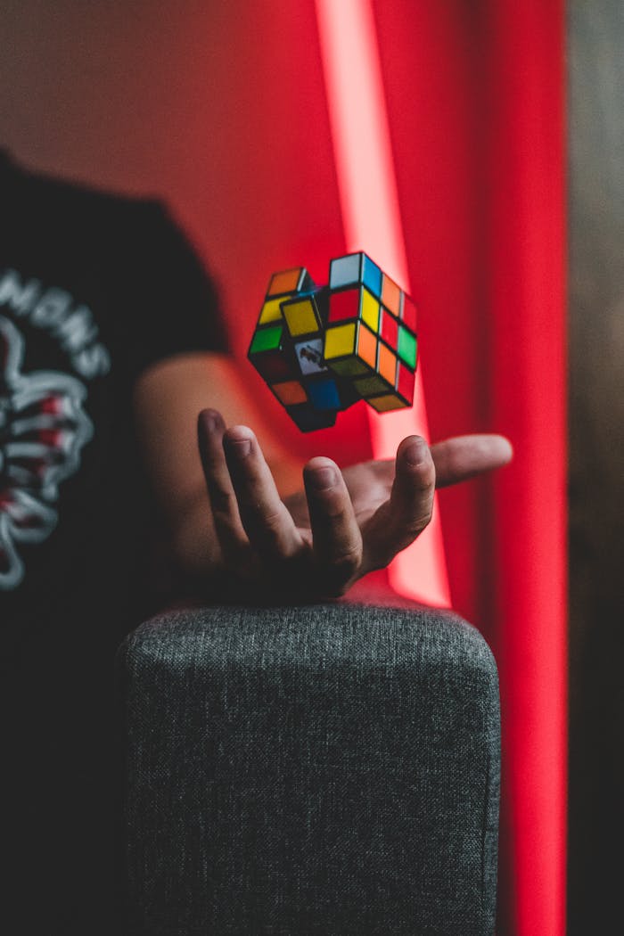 Rubik's Cube levitating over a hand with vibrant backdrop, creating a sense of whimsy and intrigue.