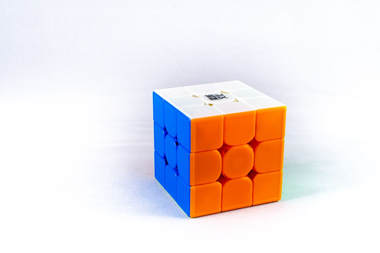 The Art of Drawing Readers In: Your attractive post title goes here Vividly colored puzzle cube featuring orange, blue, and white sides on a white background.